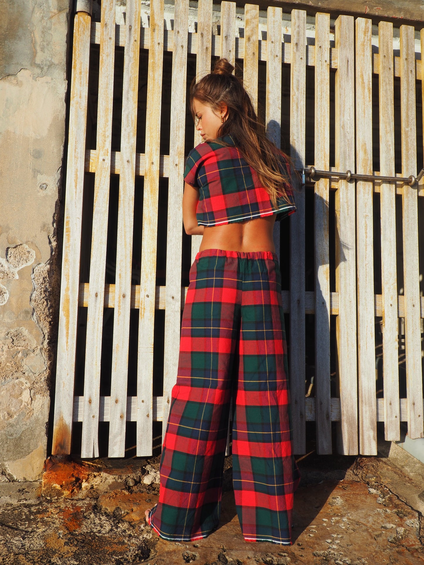 A stunning two-piece upcycled set featuring a vibrant red and blue checked design wide leg pants with elastic waste and crop top.