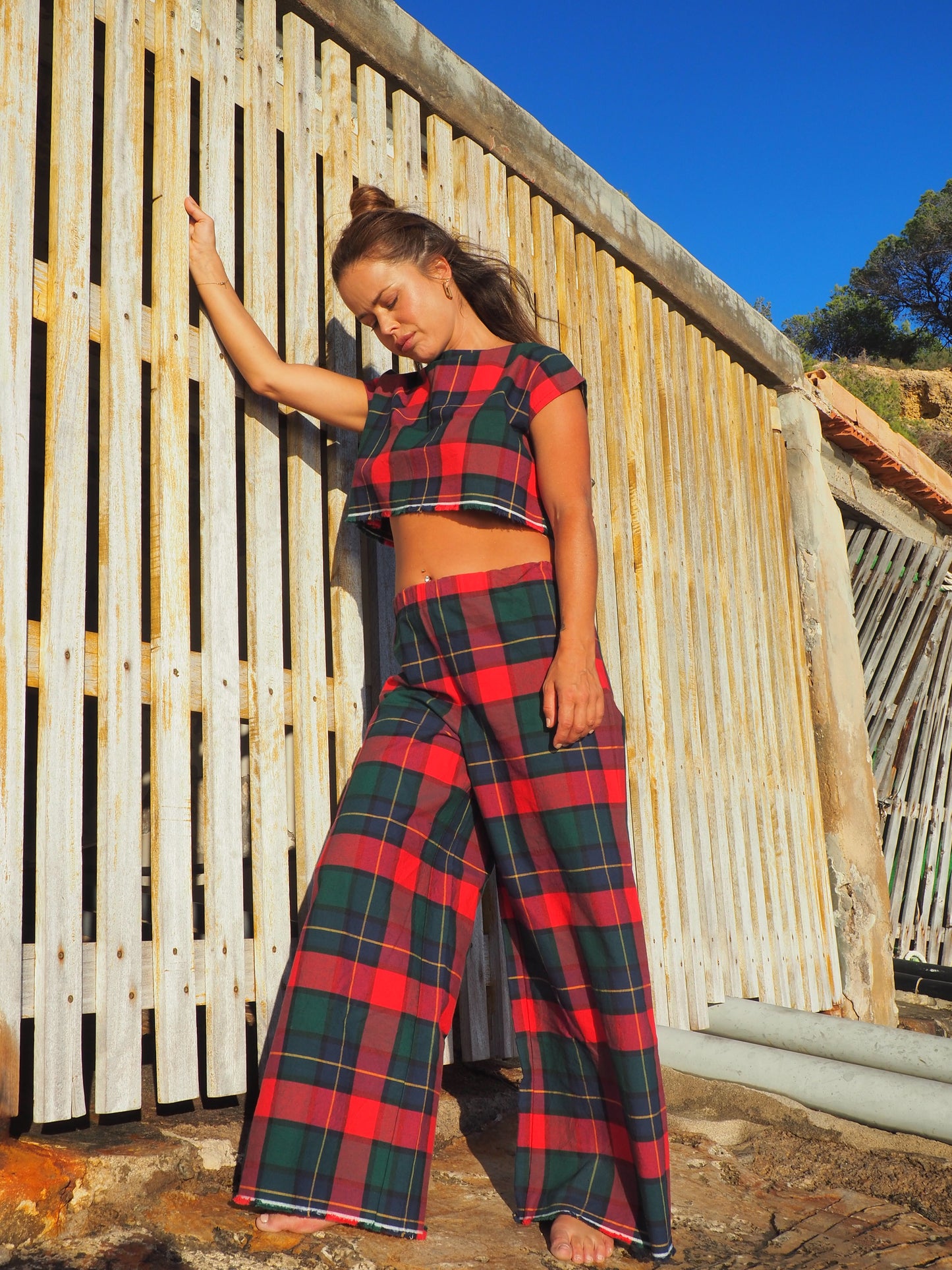 A stunning two-piece upcycled set featuring a vibrant red and blue checked design wide leg pants with elastic waste and crop top.