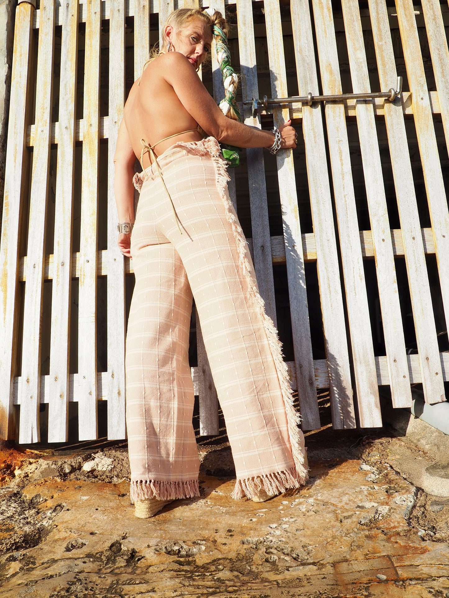 Wide leg pants with elastic waste made by vagabond Ibiza from vintage woven cotton tassel blanket with tassel side trim.