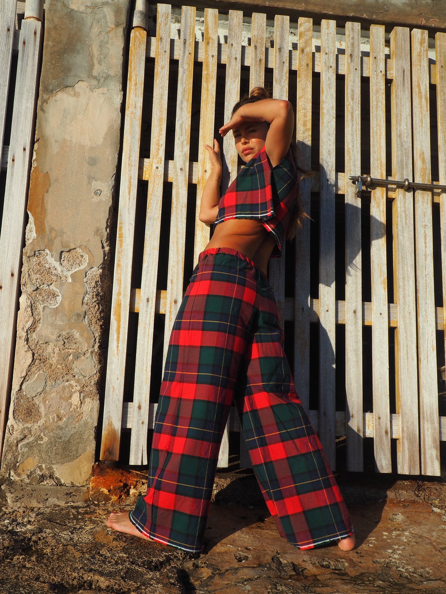 A stunning two-piece upcycled set featuring a vibrant red and blue checked design wide leg pants with elastic waste and crop top.