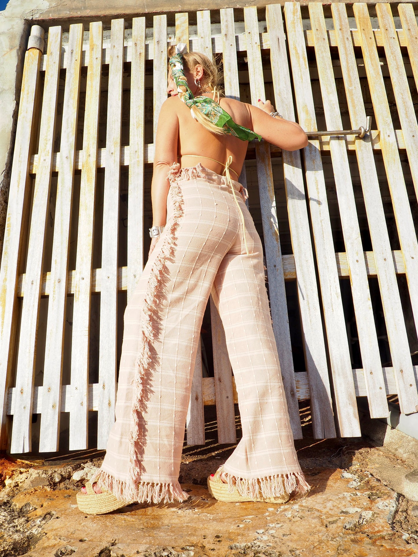 Wide leg pants with elastic waste made by vagabond Ibiza from vintage woven cotton tassel blanket with tassel side trim.