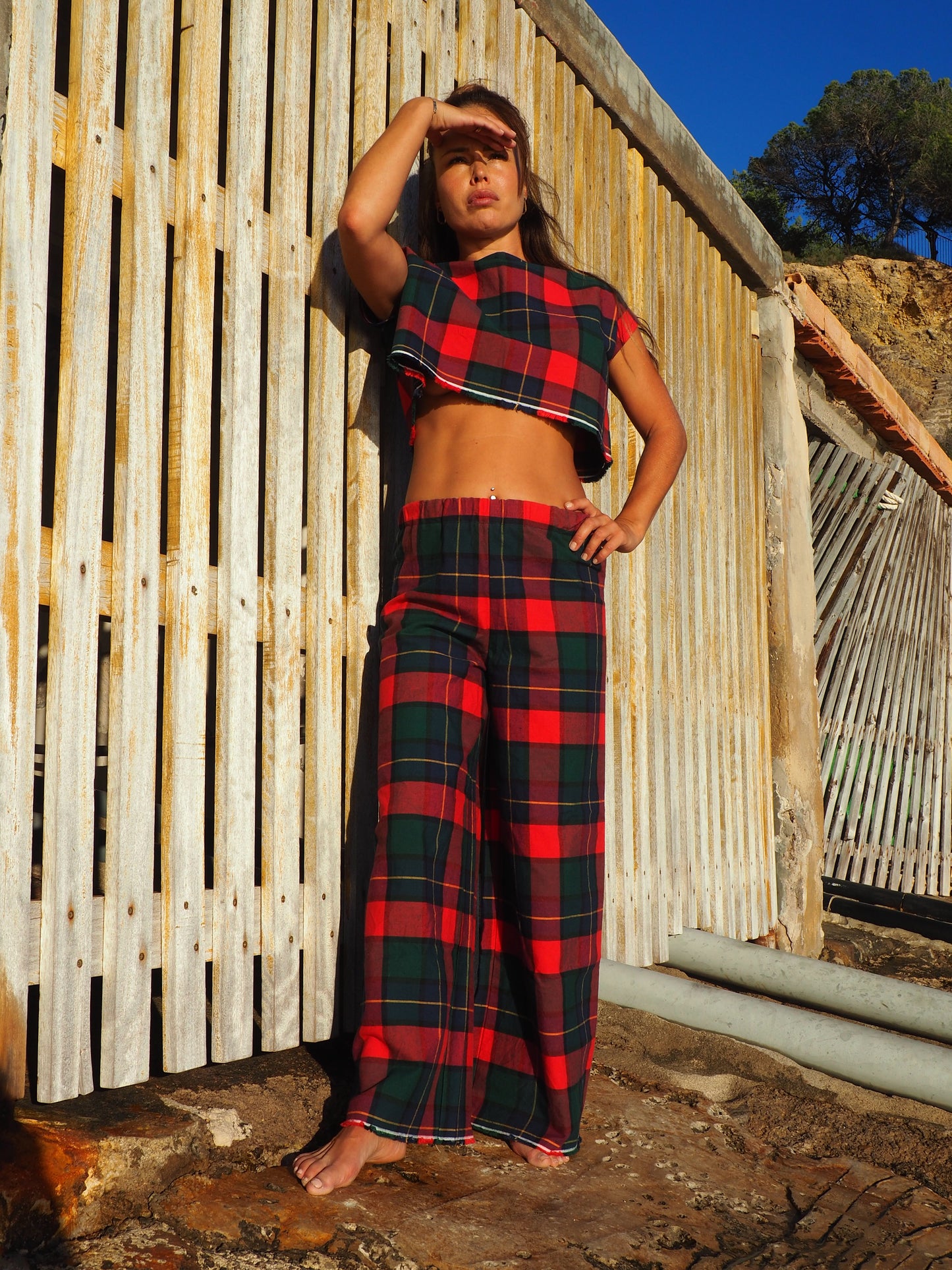 A stunning two-piece upcycled set featuring a vibrant red and blue checked design wide leg pants with elastic waste and crop top.