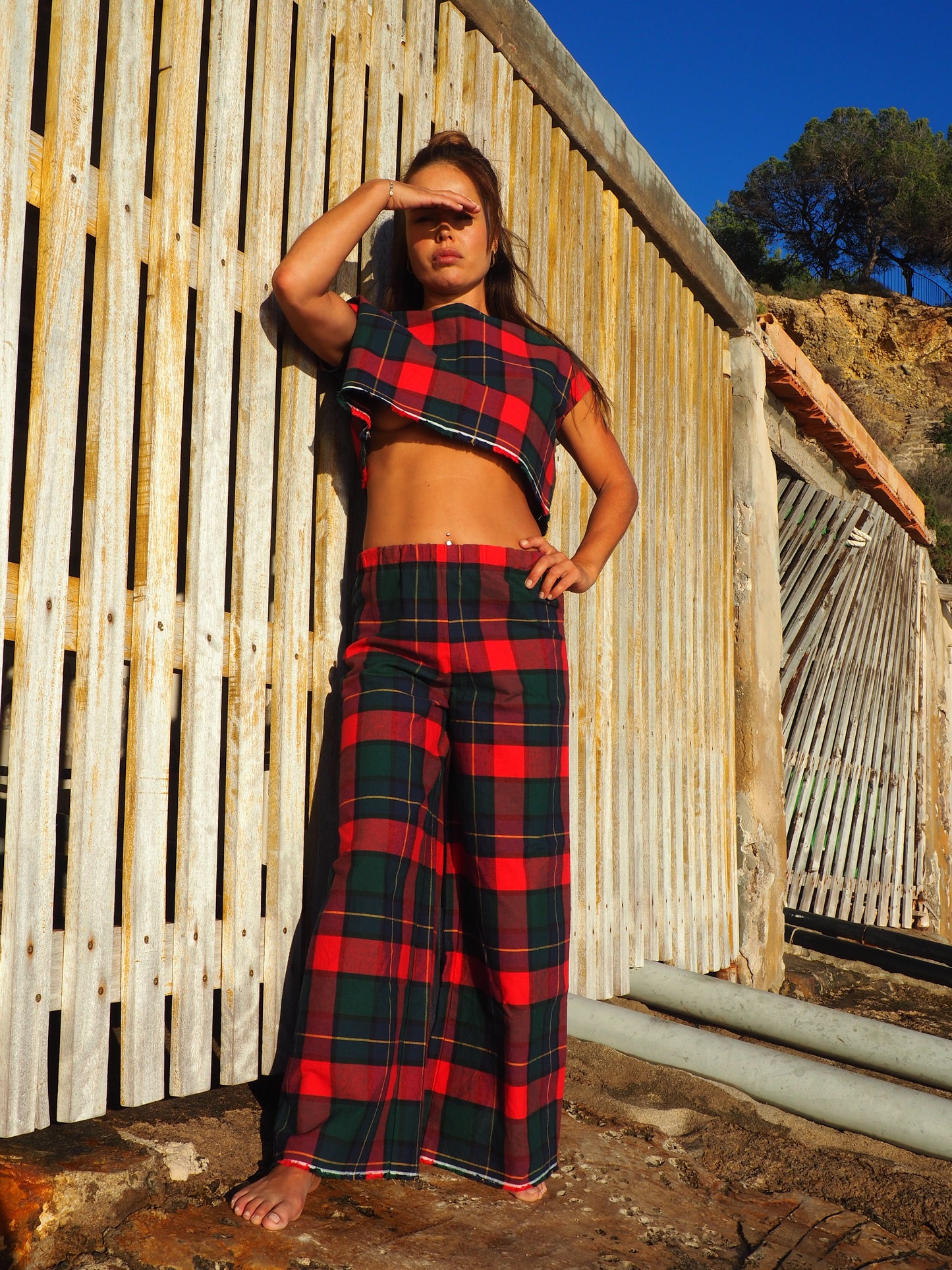 A stunning two-piece upcycled set featuring a vibrant red and blue checked design wide leg pants with elastic waste and crop top.